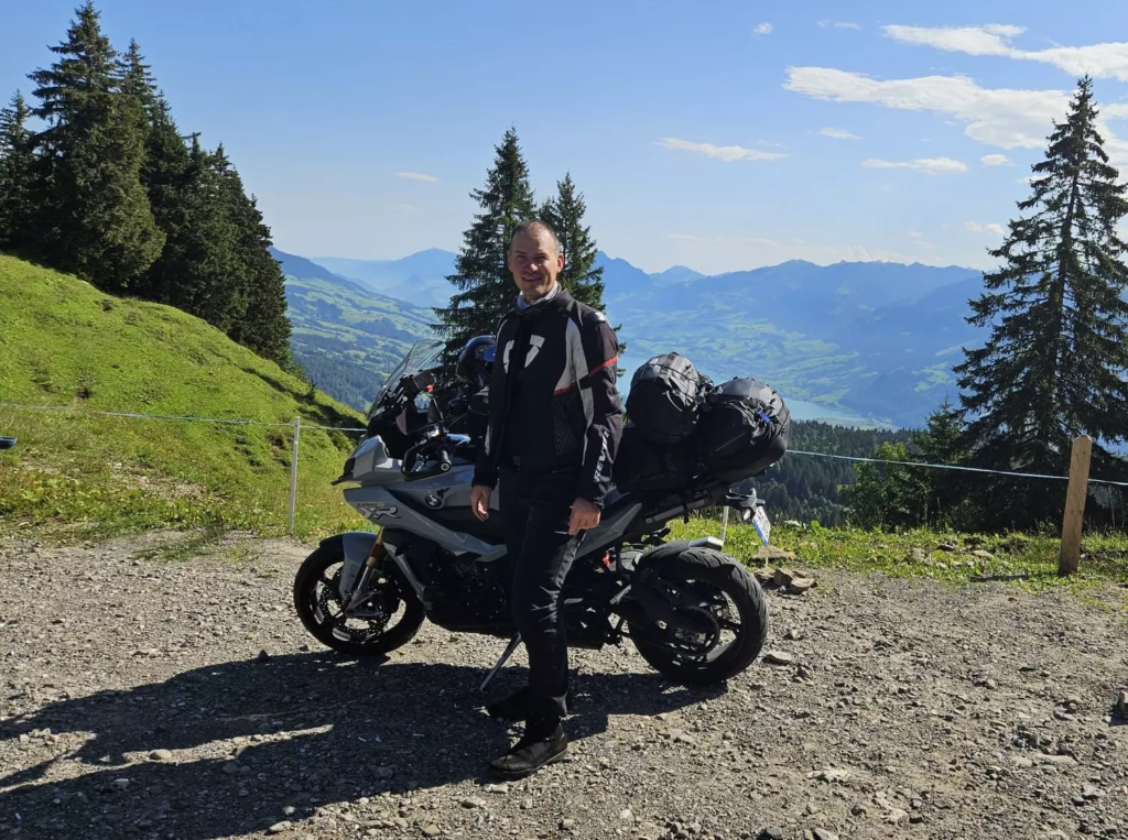 Intars devant sa moto et un paysage de montagne