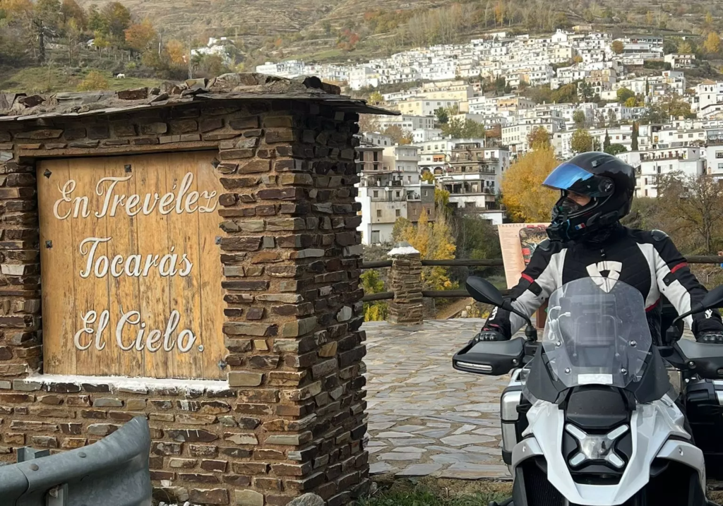 Intars en moto devant un village espagnol